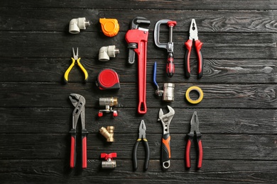 Flat lay composition with plumber's tools on wooden background