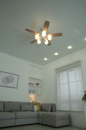 Photo of Ceiling fan, furniture and accessories in stylish living room, low angle view