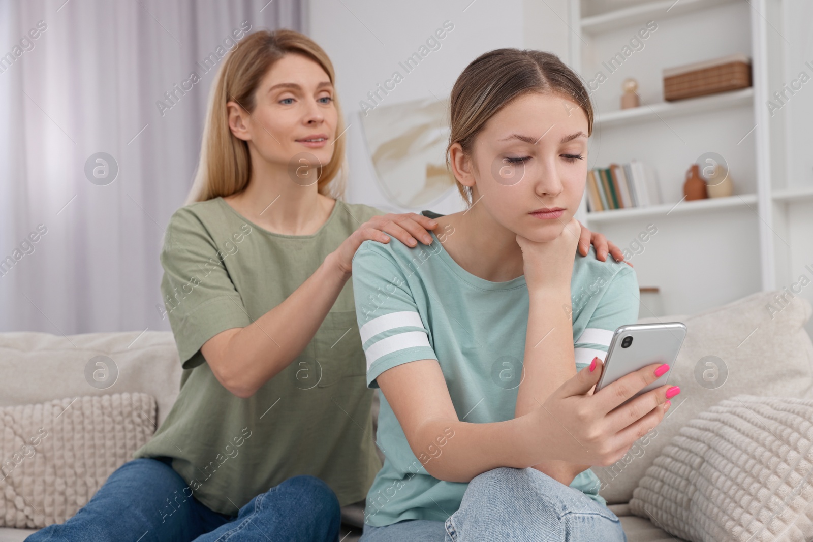 Photo of Mother comforting her upset teen daughter at home