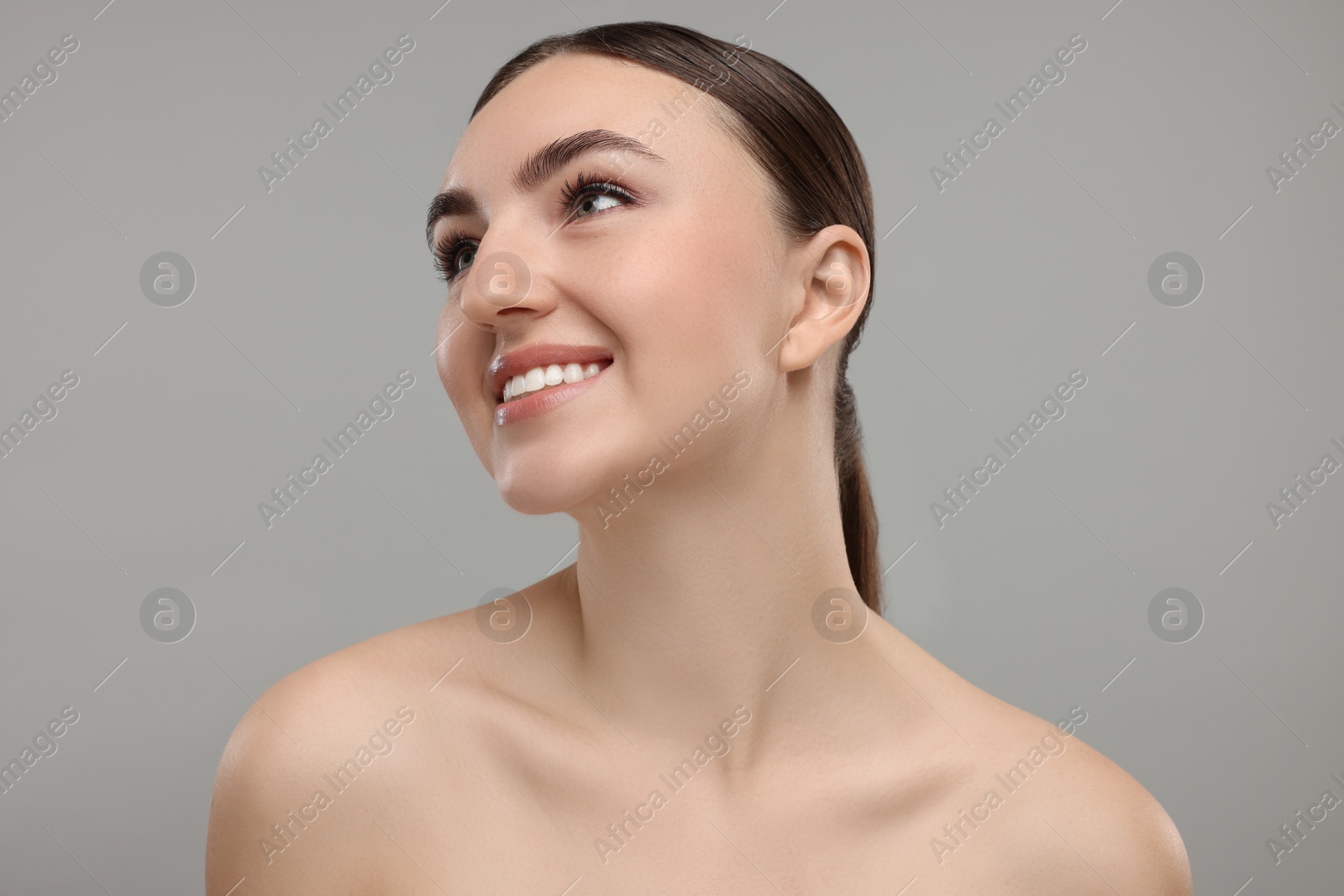 Photo of Portrait of smiling woman on grey background