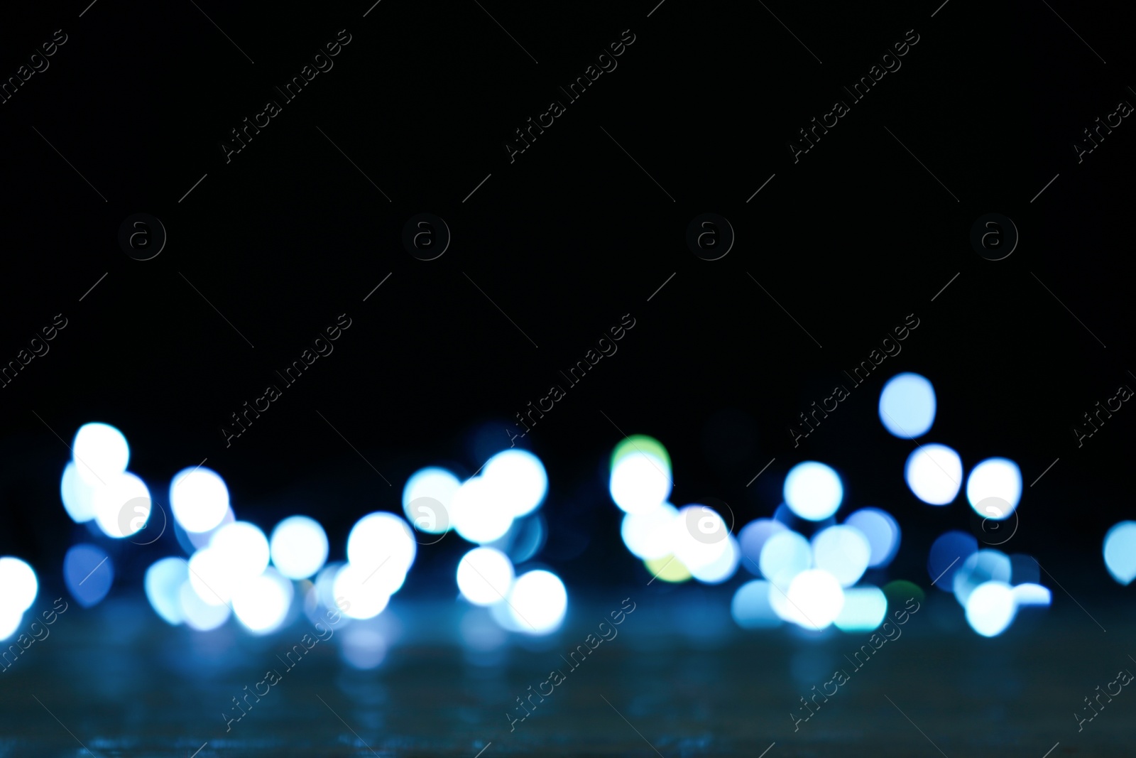 Photo of Blurred view of beautiful lights on black background. Bokeh effect