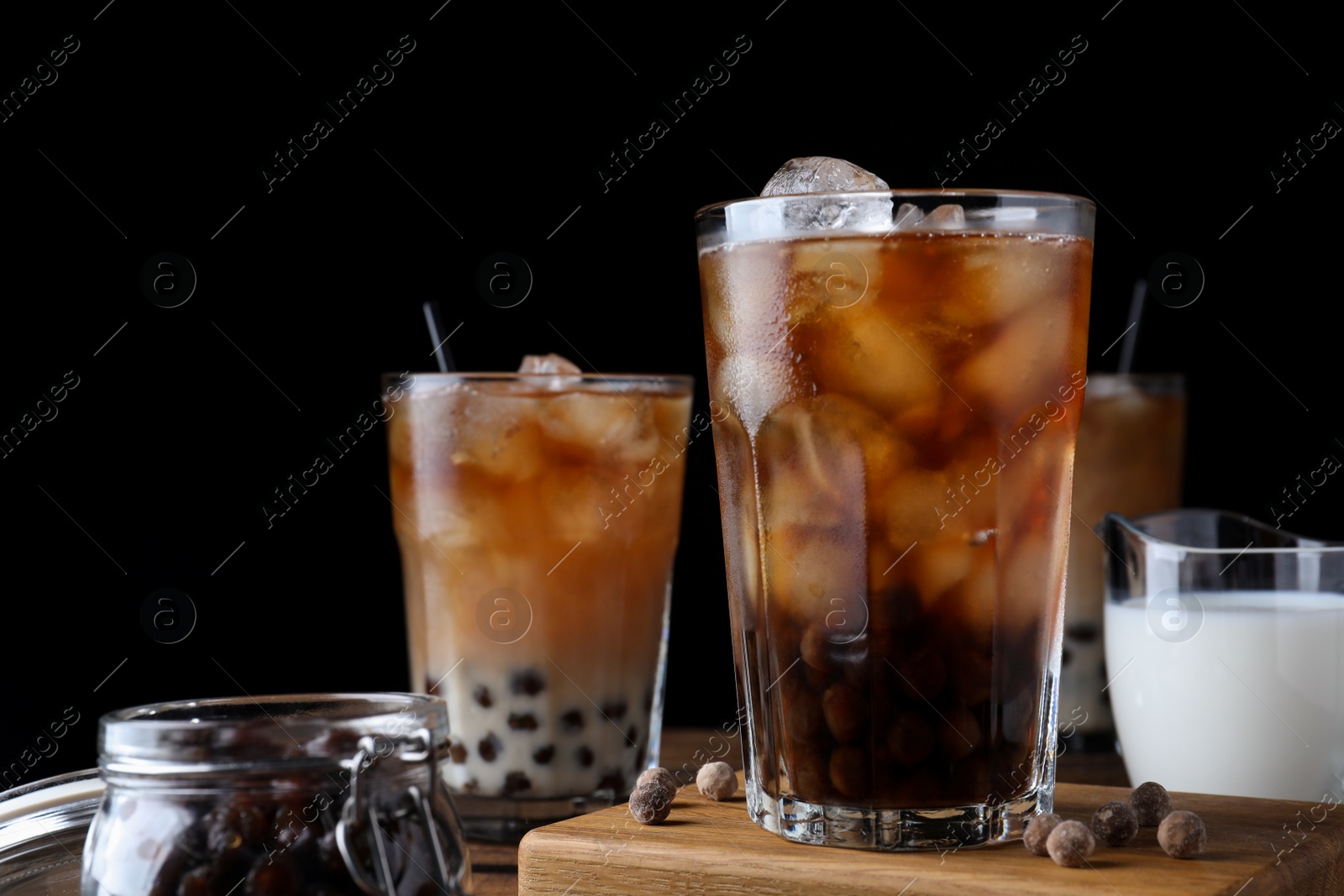 Photo of Tasty milk bubble tea on wooden table, closeup