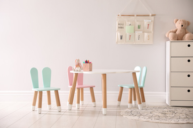 Small table and chairs with bunny ears indoors. Children's room interior