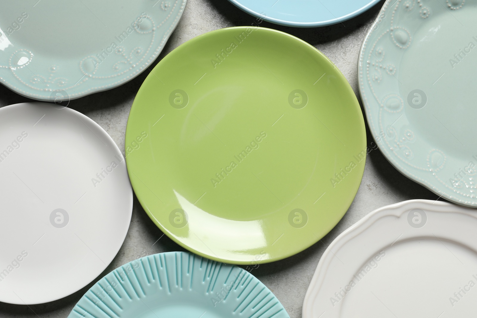 Photo of Beautiful ceramic plates on light grey table, flat lay