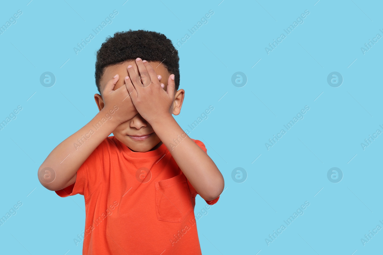 Photo of Emotional African-American boy on turquoise background. Space for text