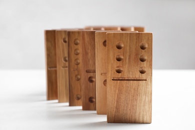 Photo of Beautiful wooden dominoes on white table, closeup