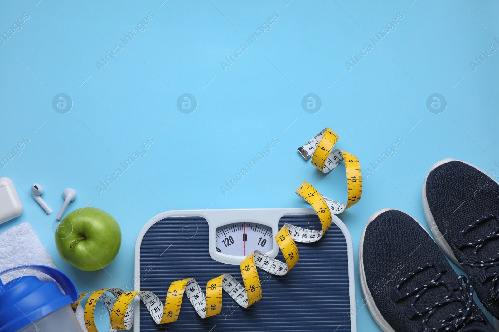 Photo of Flat lay composition with scales and measuring tape on light blue background, space for text