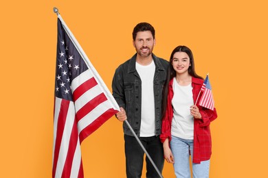 4th of July - Independence Day of USA. Happy man and his daughter with American flag on yellow background