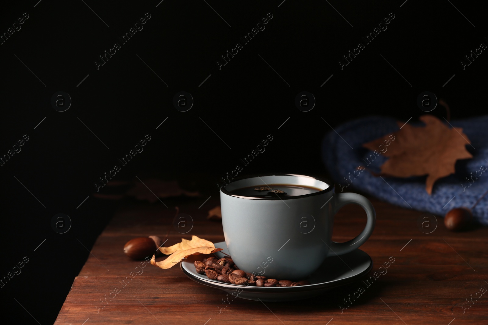 Photo of Composition with cup of hot cozy drink and autumn leaves on table