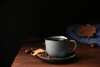 Composition with cup of hot cozy drink and autumn leaves on table