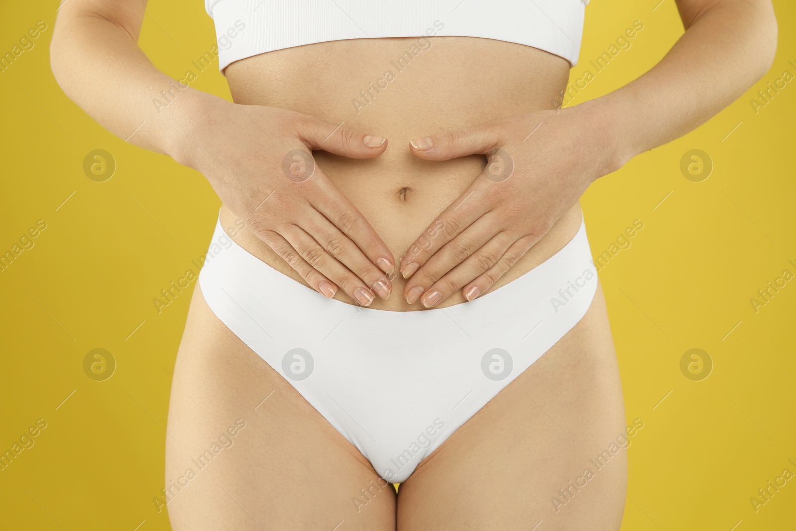 Photo of Gynecology. Woman in underwear on yellow background, closeup