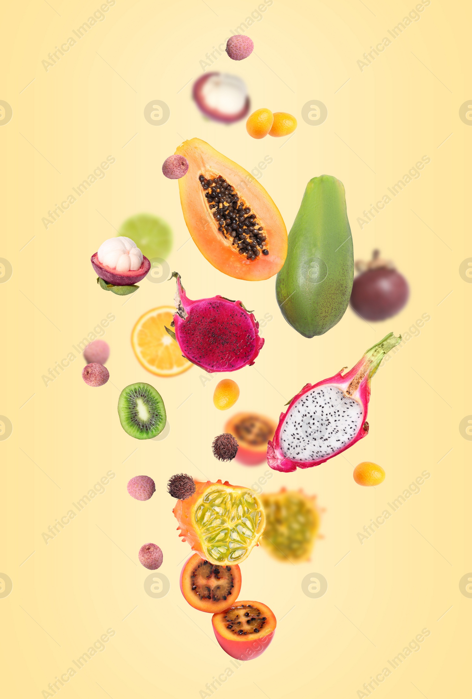 Image of Different tasty exotic fruits flying on yellow background