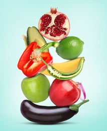 Stack of different vegetables and fruits on light blue background