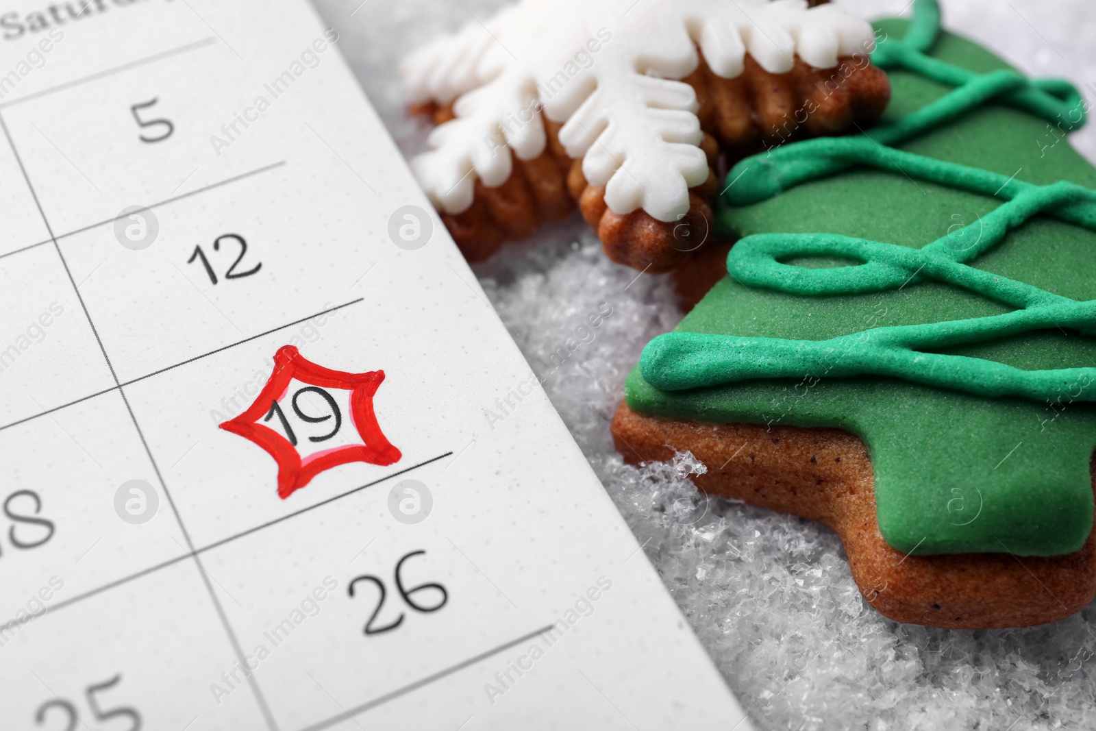 Photo of Saint Nicholas Day. Calendar with marked date December 19 and gingerbread cookies on snow, closeup