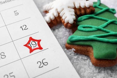 Photo of Saint Nicholas Day. Calendar with marked date December 19 and gingerbread cookies on snow, closeup