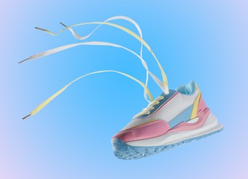 Image of One stylish sneaker in air on blue gradient background