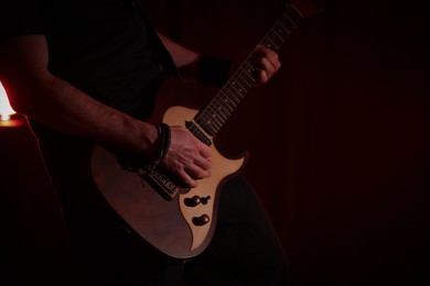 Photo of Man playing electric guitar on stage, closeup. Rock music