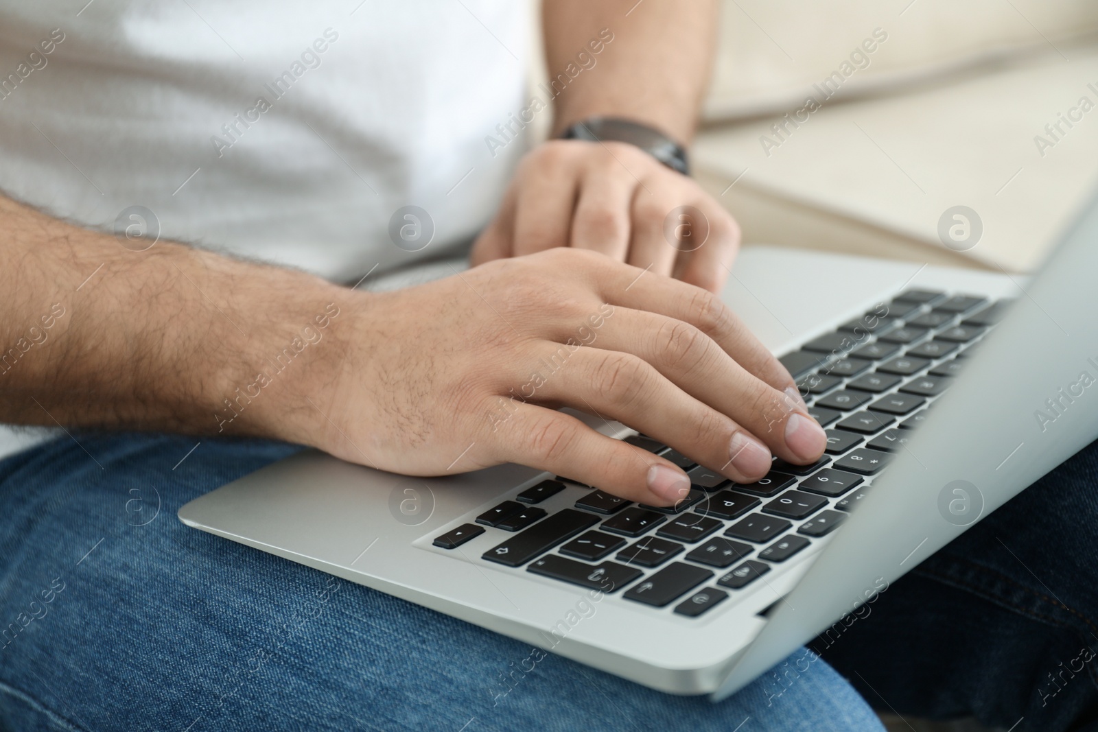 Photo of Man working on modern laptop at home, closeup