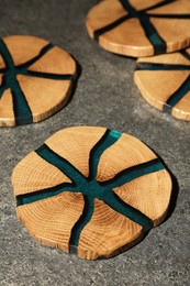Stylish wooden cup coasters on grey table