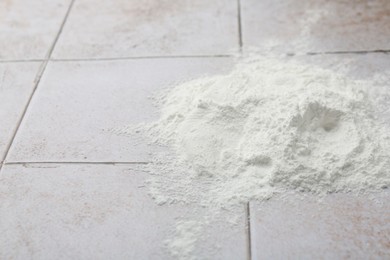 Photo of Pile of baking powder on light tiled table, closeup. Space for text