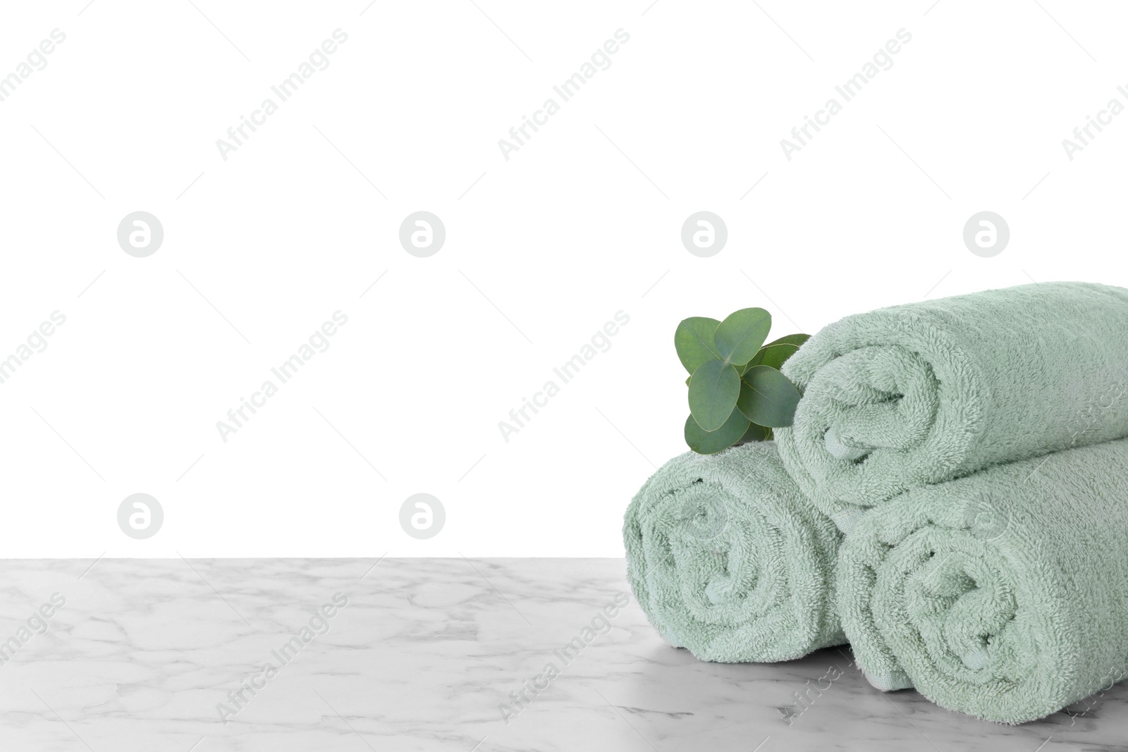 Photo of Fresh towels and eucalyptus branch on marble table against white background. Space for text