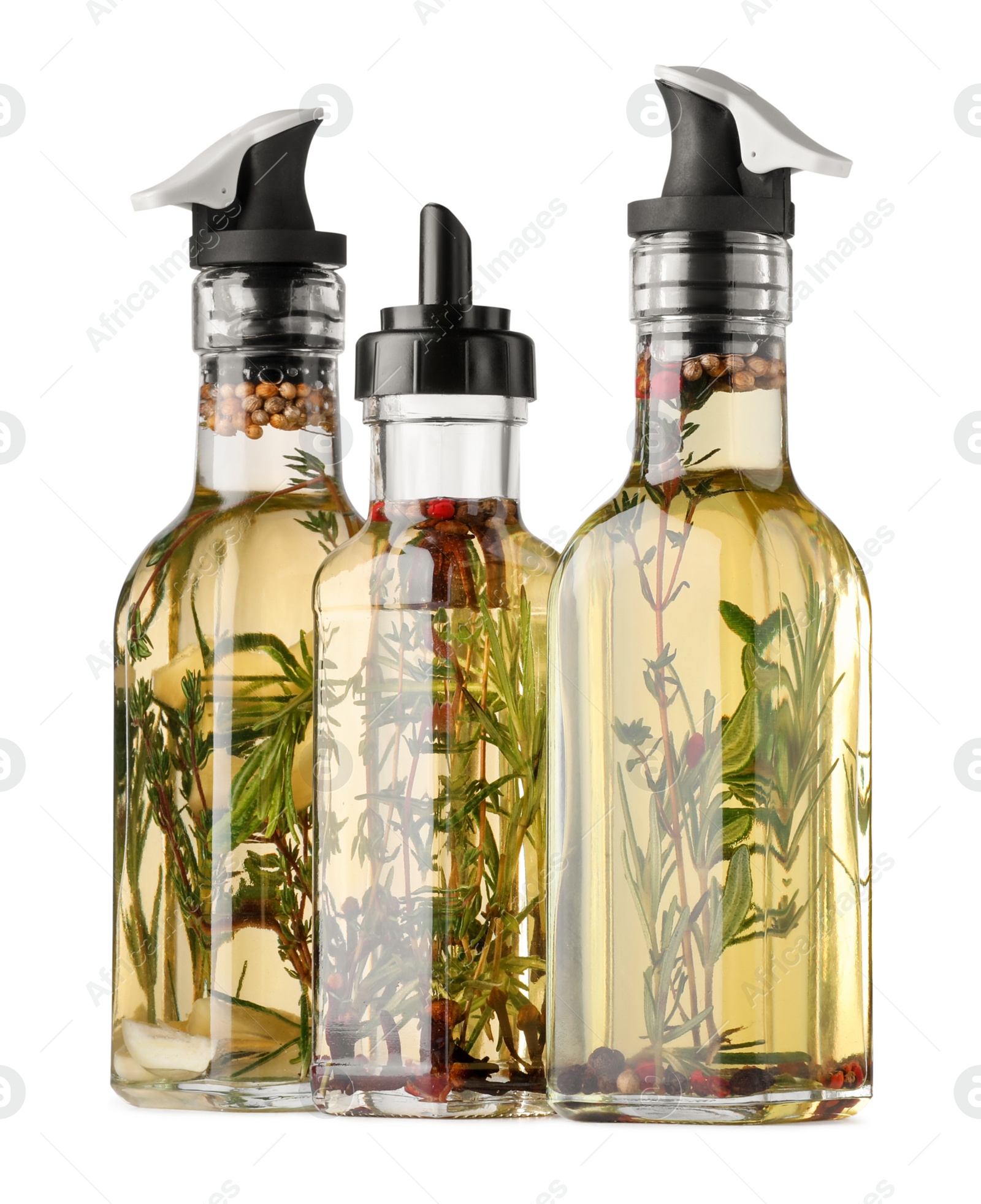 Photo of Different sorts of cooking oil with spices and herbs in bottles on white background