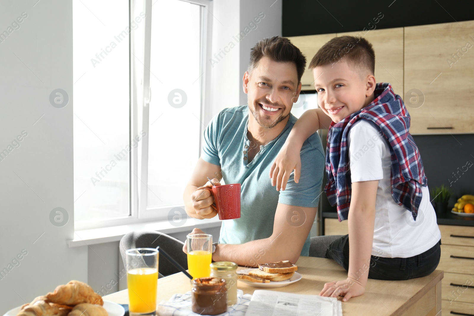 Photo of Dad and son having breakfast together in kitchen