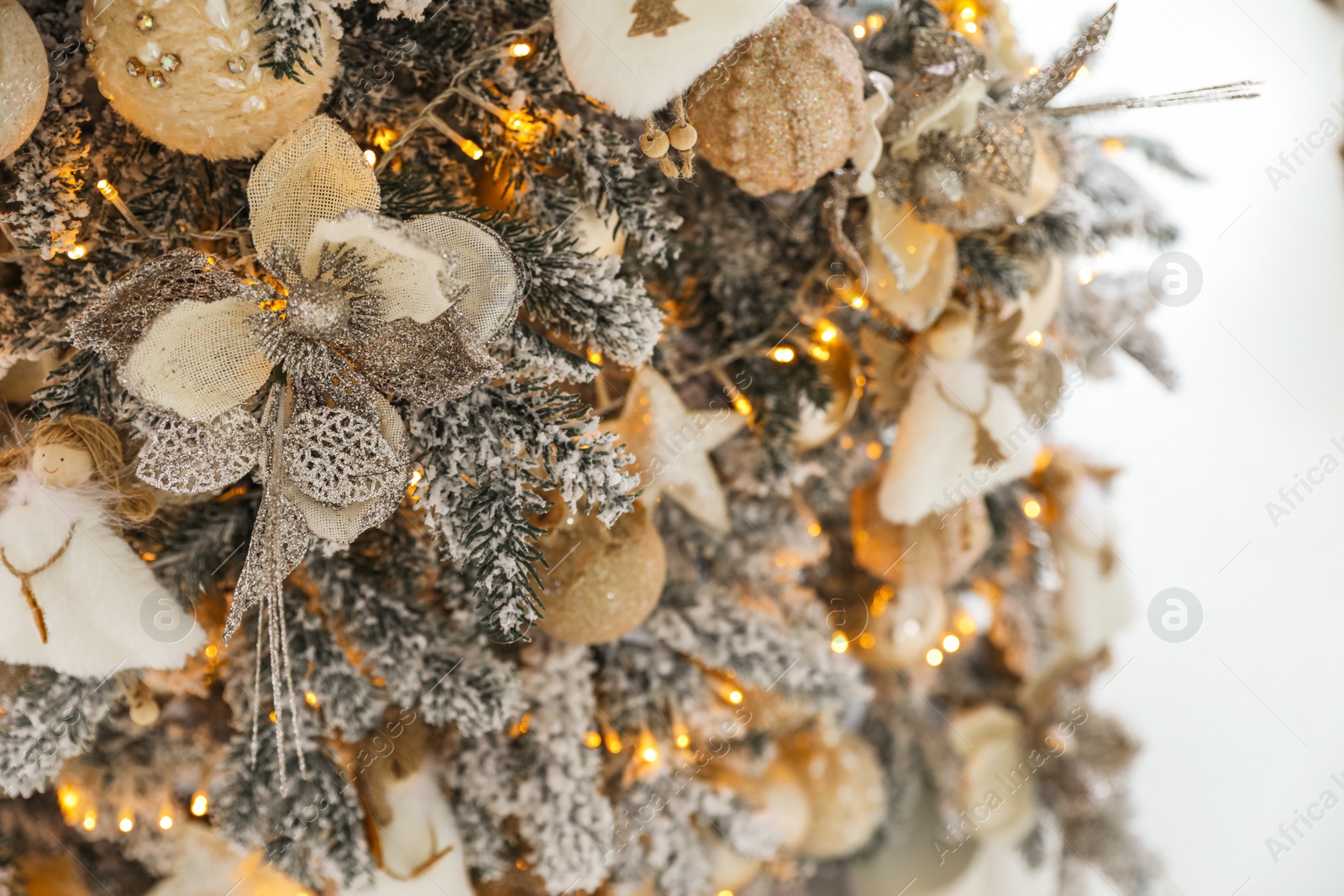 Photo of Beautiful Christmas tree on light background, closeup. Festive interior decoration