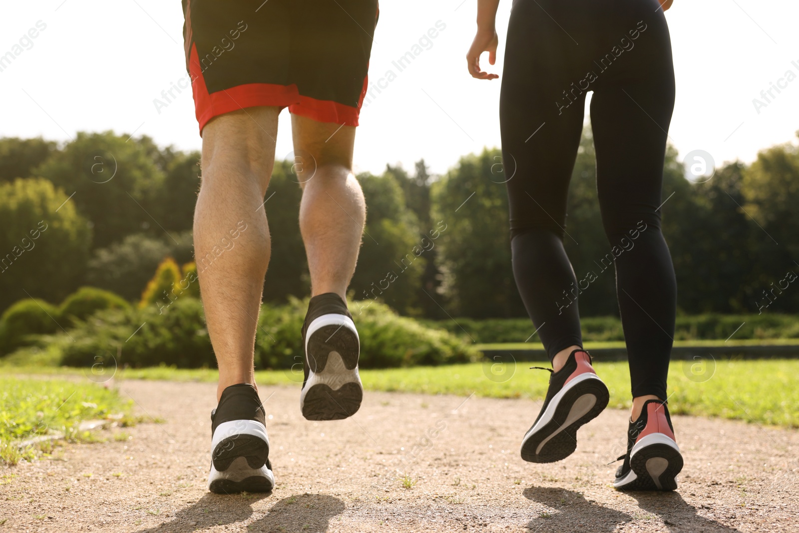 Photo of Healthy lifestyle. Couple running outdoors on sunny day, closeup