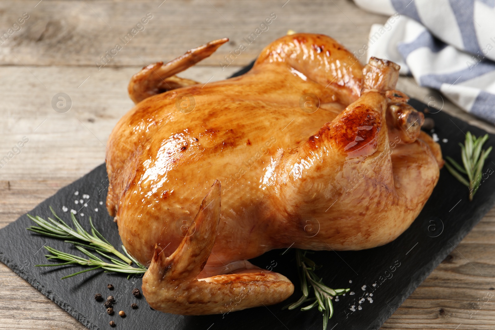 Photo of Tasty roasted chicken with spices on wooden table