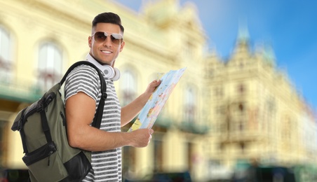 Image of Happy traveler with map in foreign city. Summer vacation trip