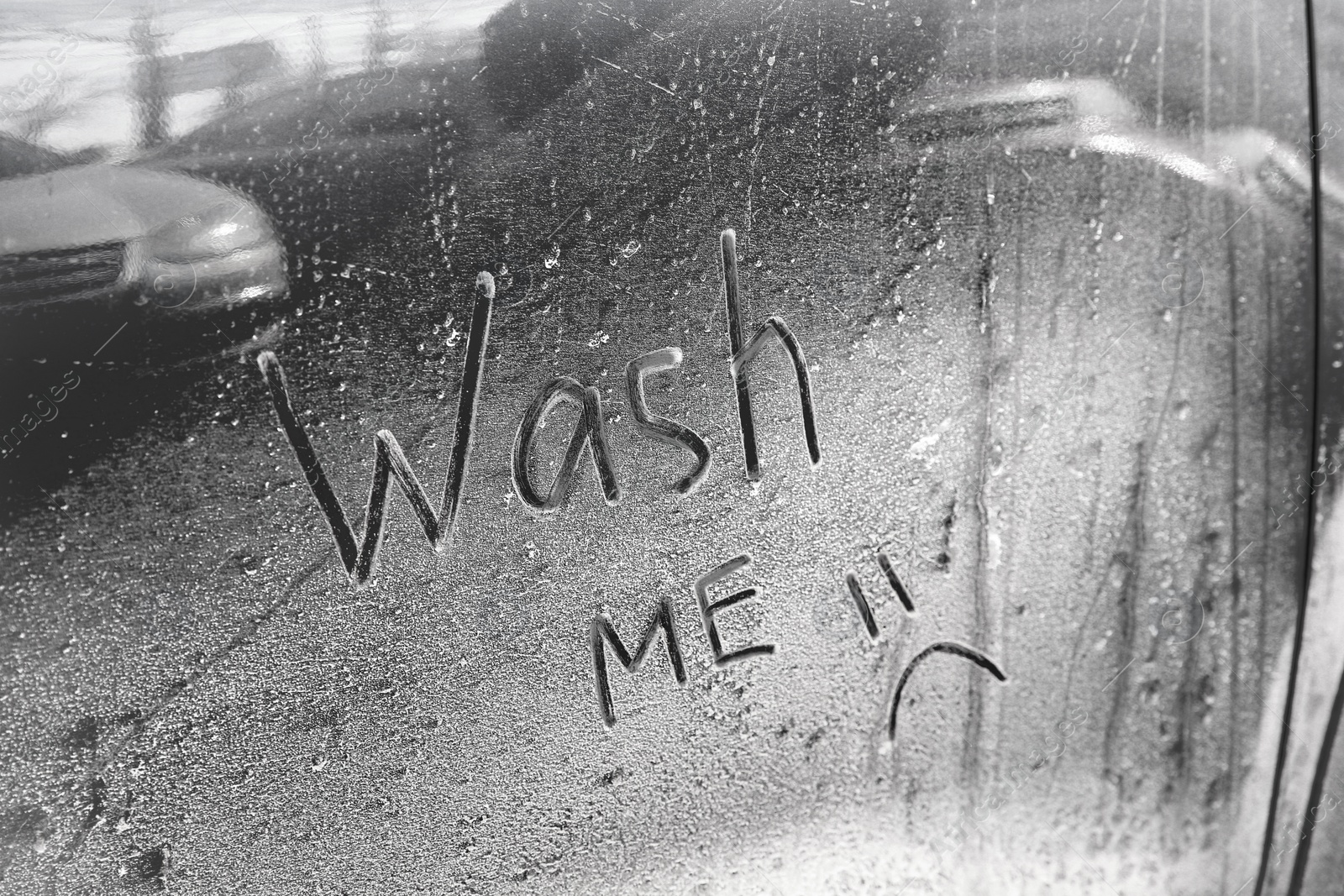 Photo of Inscription WASH ME and sad smiley on car door, closeup