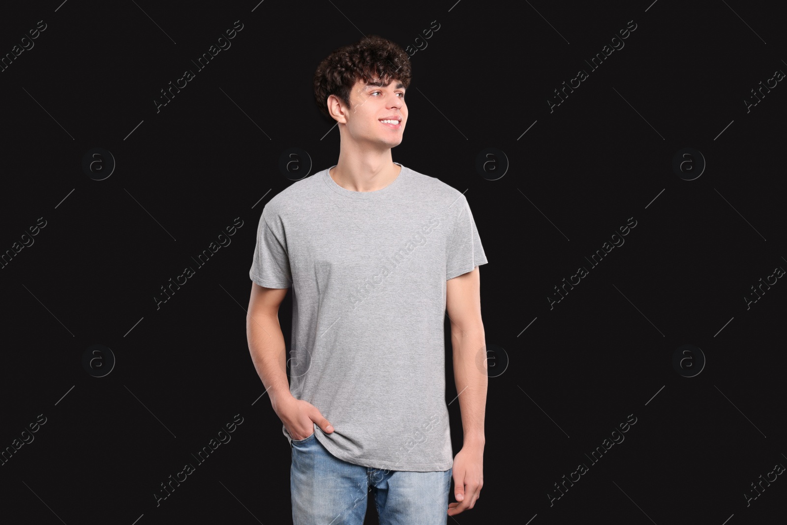 Photo of Man wearing light gray t-shirt on black background. Mockup for design