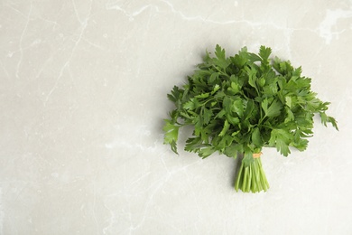 Photo of Bunch of fresh green parsley on light background, view from above. Space for text