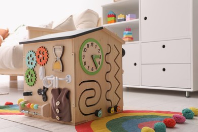 Photo of Busy board house on floor indoors, space for text. Baby sensory toy