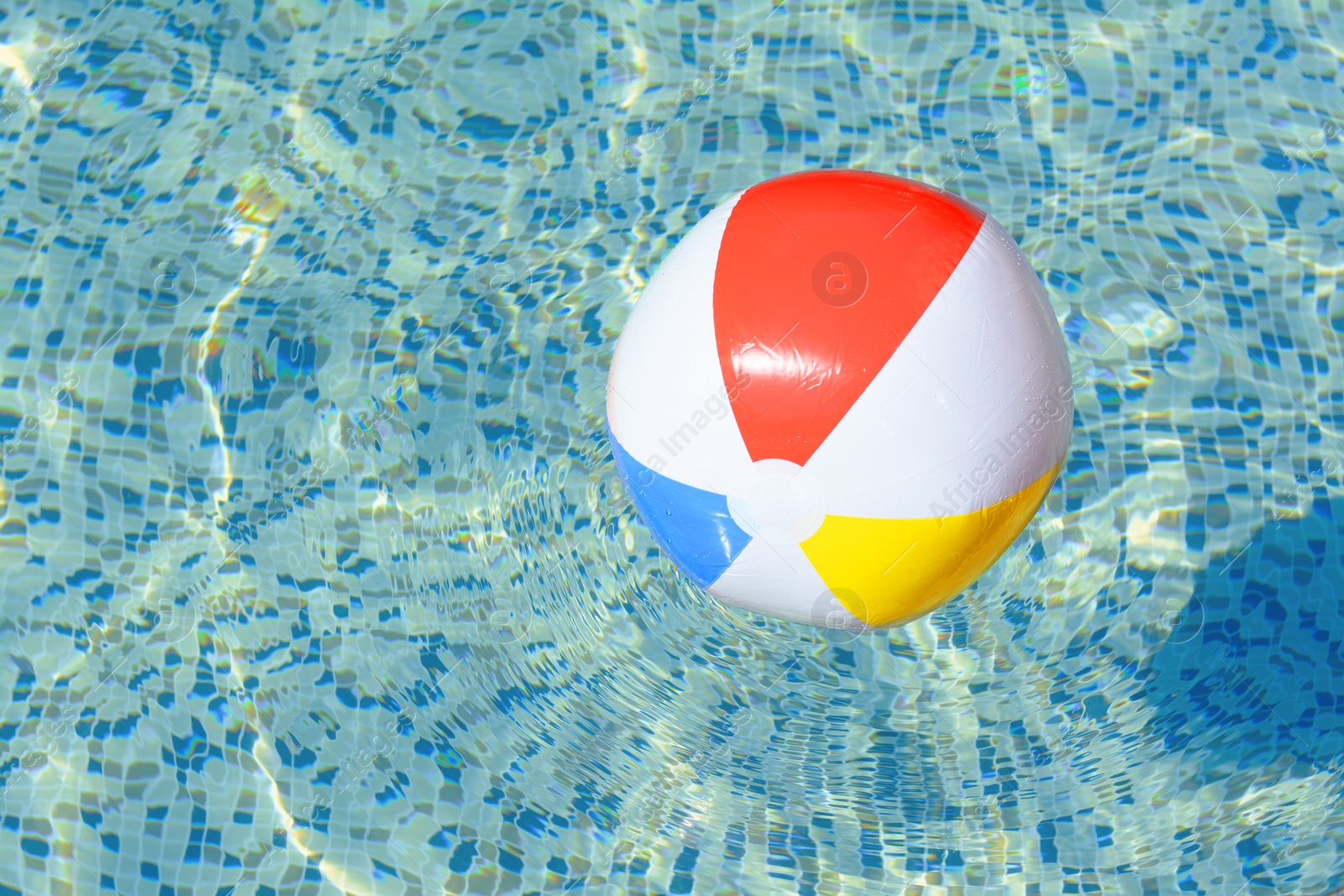 Photo of Inflatable beach ball floating in swimming pool, space for text