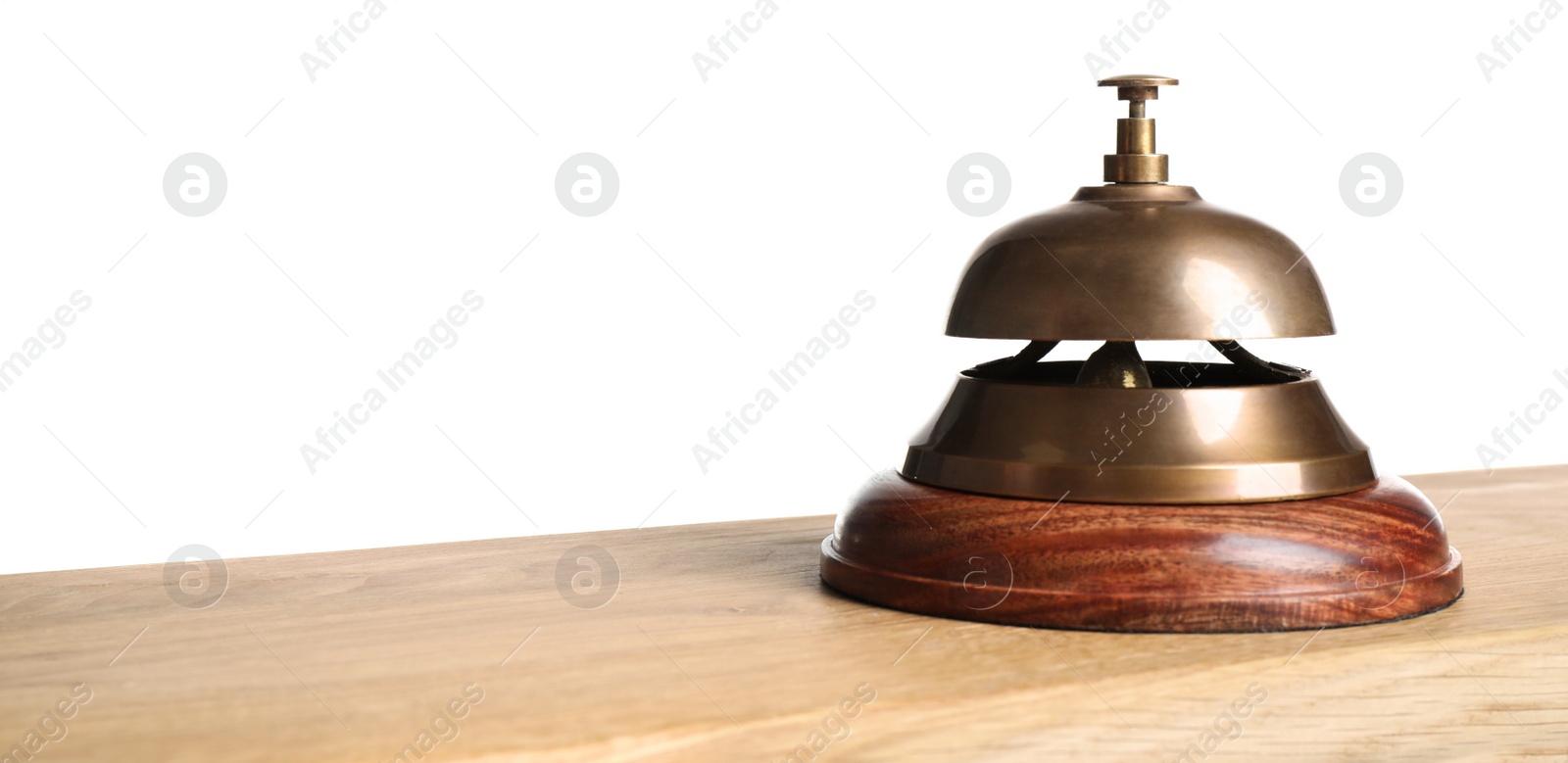 Photo of Hotel service bell on wooden table against white background, closeup