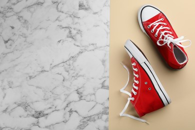Photo of Pair of red sneakers on color background, flat lay. Space for text