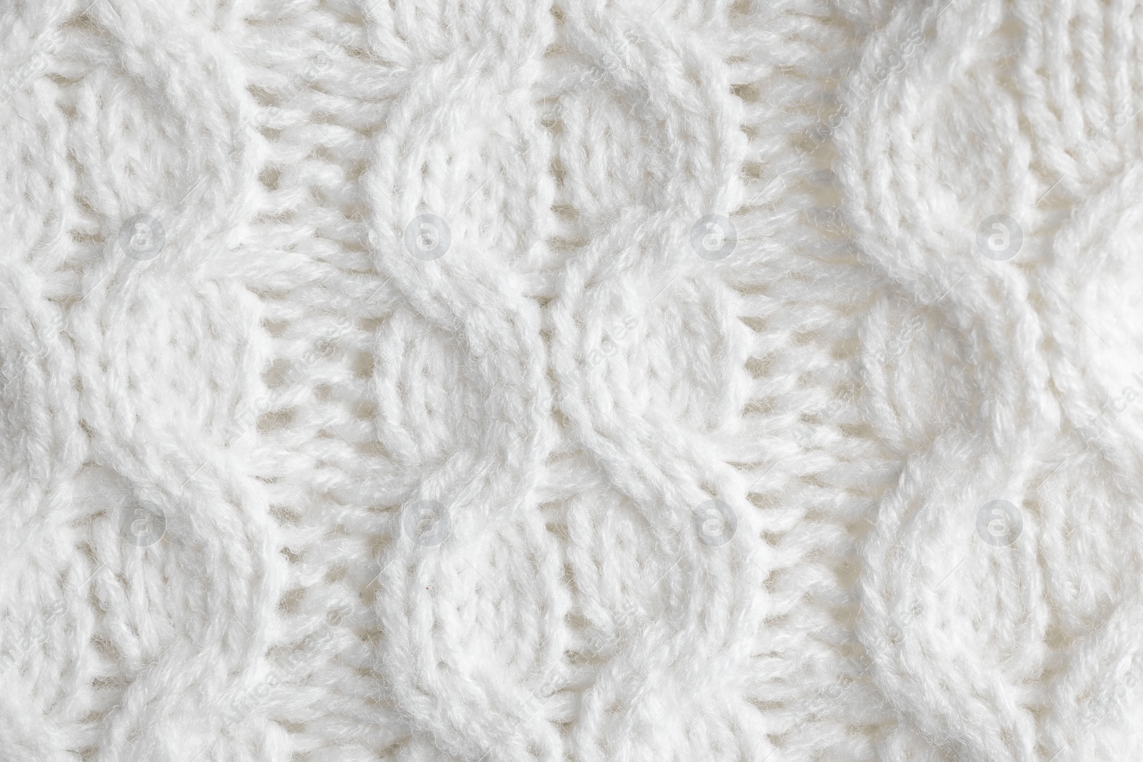 Photo of White knitted sweater as background, closeup view