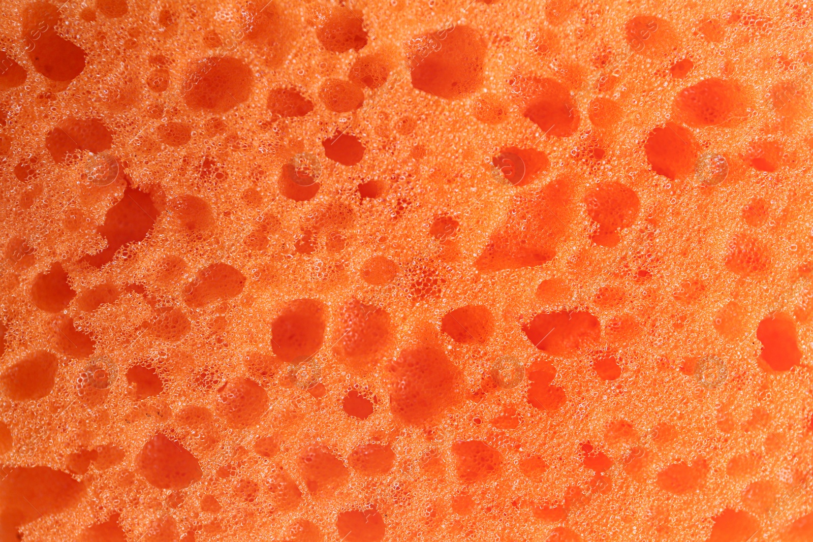 Photo of Clean orange sponge as background, top view