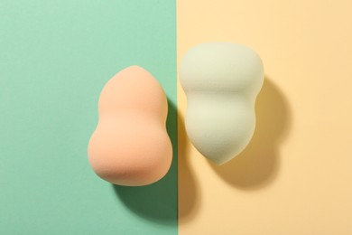Different makeup sponges on color background, flat lay