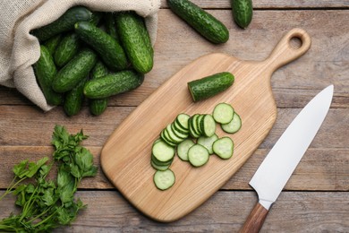 Photo of Fresh ripe cucumbers and parsley on wooden table, flat lay