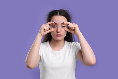 Photo of Tired young woman on purple background. Insomnia problem