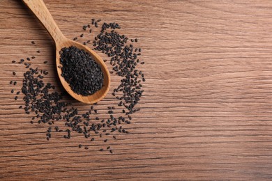 Photo of Black sesame seeds on wooden table, flat lay. Space for text