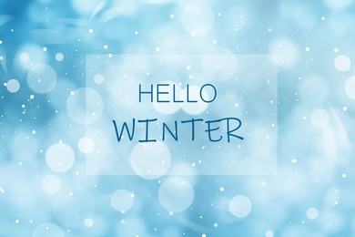 Image of Phrase Hello Winter and snowfall on light blue background, bokeh effect