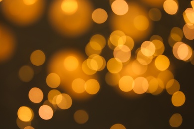 Photo of Blurred view of gold lights on dark background. Bokeh effect