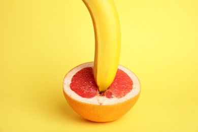 Fresh grapefruit and banana on yellow background. Sex concept