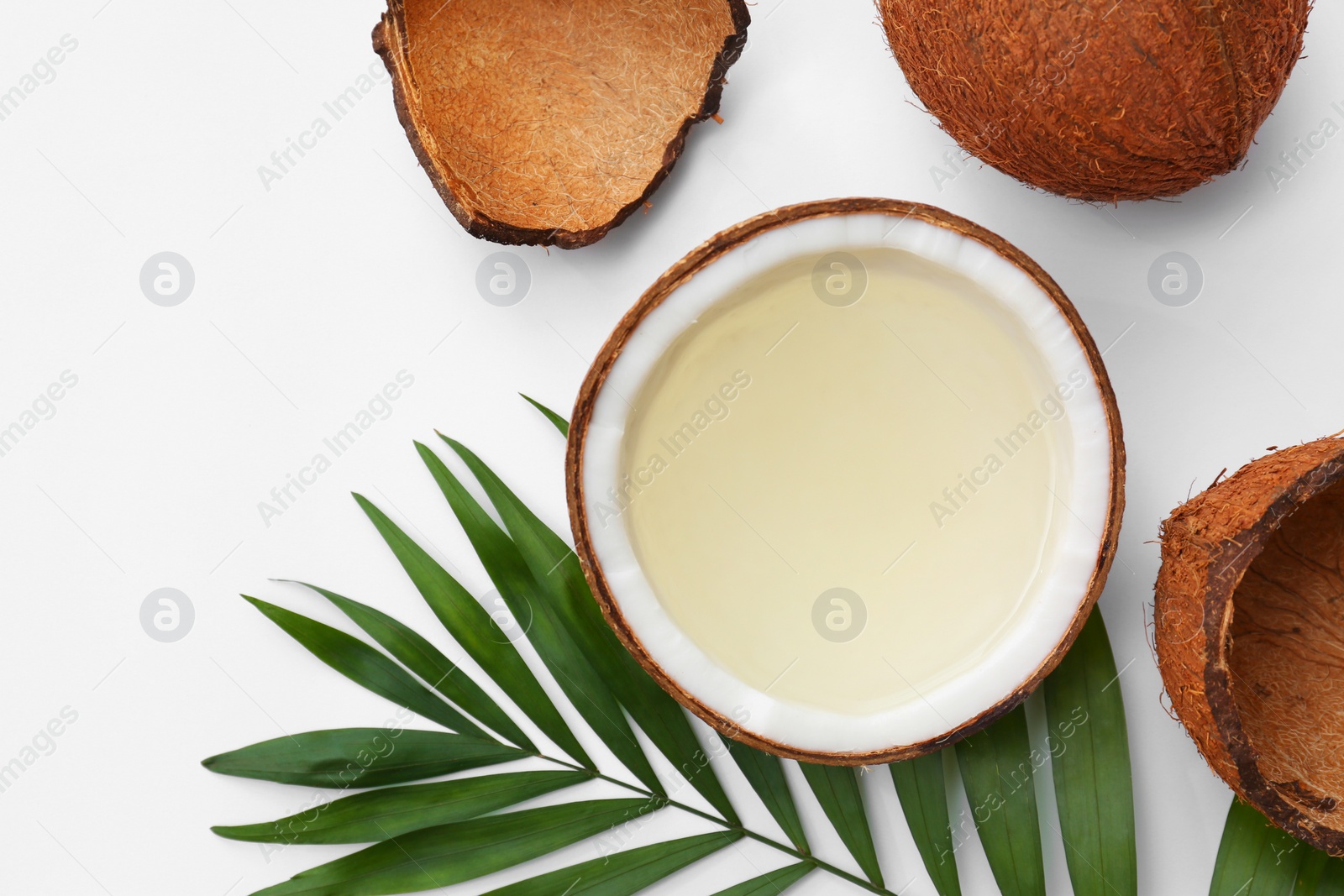 Photo of Composition with drink in half of coconut and palm leaf on white background, top view