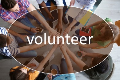 Group of volunteers putting hands together indoors, top view