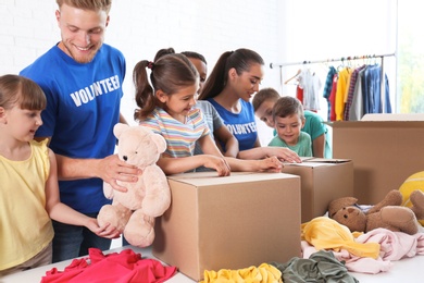 Volunteers with children sorting donation goods indoors